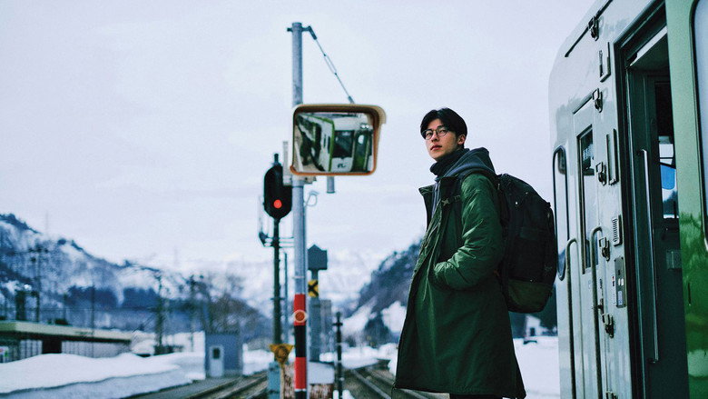 Jimmy standing beside a train at a snowy station in 18×2